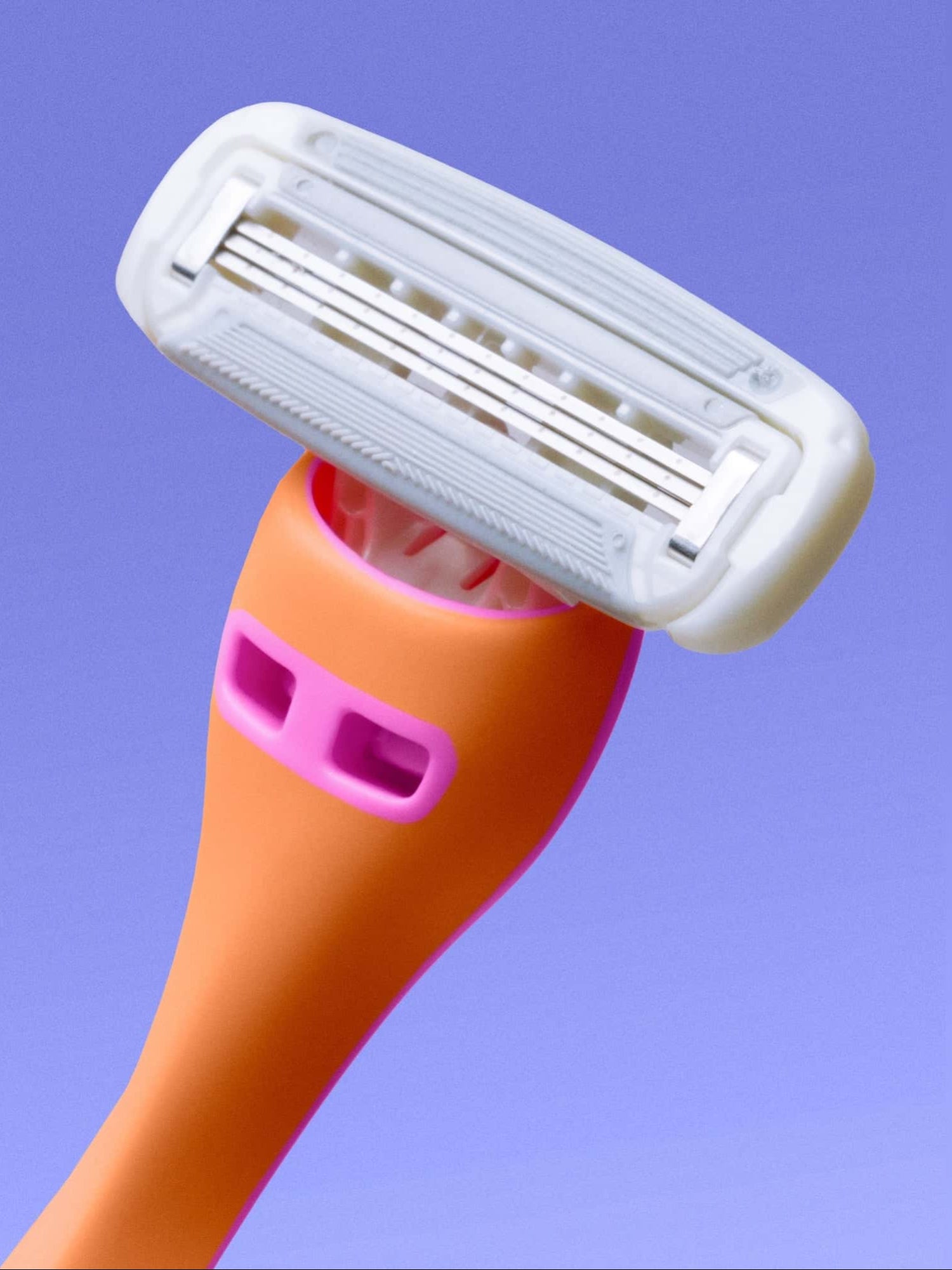 A brightly colored razor with an orange handle and pink accents features a multi-blade head, positioned against a light purple background.