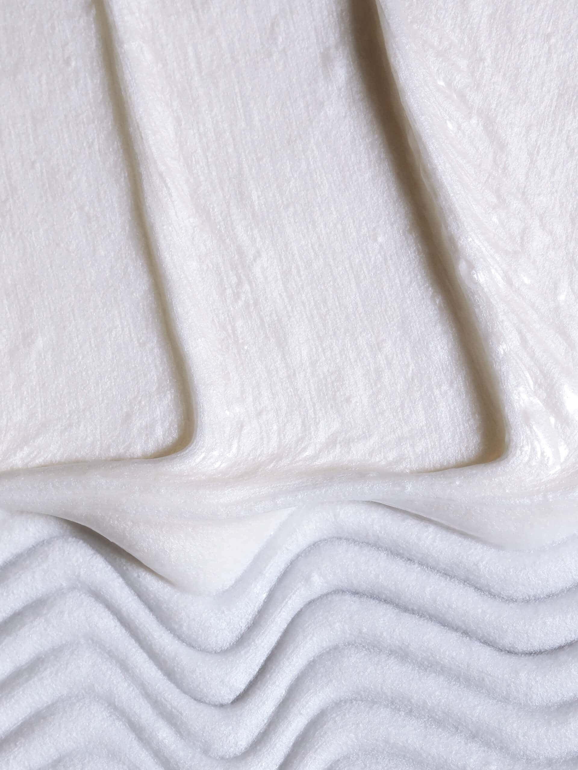 Smooth white shave cream peak highlighting creamy texture and elegant swirl.